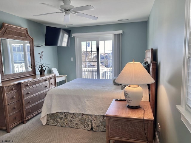 carpeted bedroom with ceiling fan and access to exterior