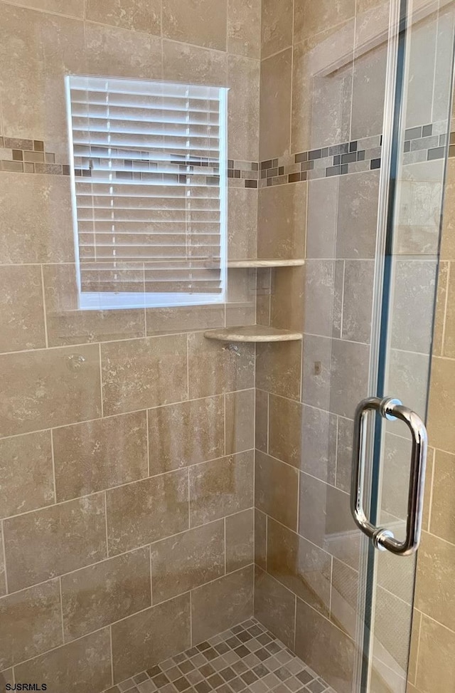 bathroom with a shower with door