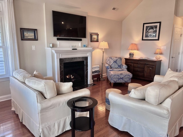 living room featuring lofted ceiling, a premium fireplace, and dark hardwood / wood-style floors