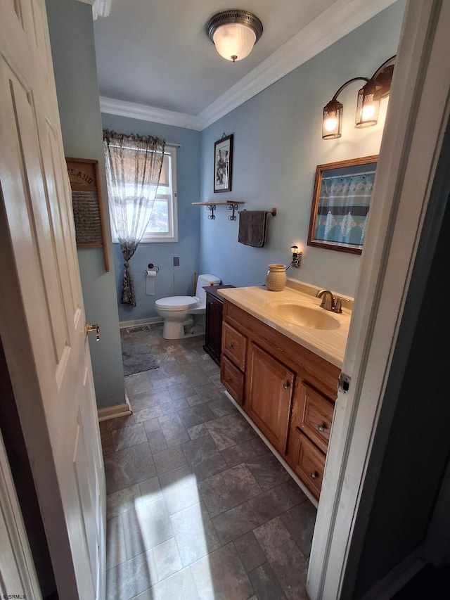 bathroom featuring crown molding, vanity, and toilet