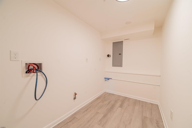 washroom with electric panel, hookup for a washing machine, and light wood-type flooring