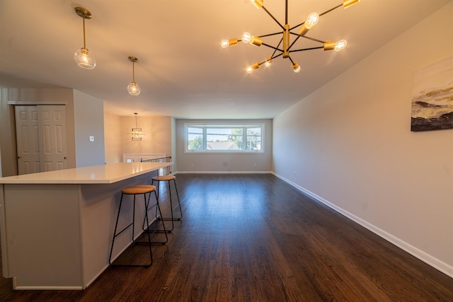 kitchen with dark hardwood / wood-style floors, a kitchen bar, decorative light fixtures, and a kitchen island