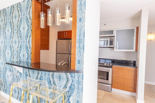 kitchen featuring light tile patterned floors, decorative light fixtures, stainless steel appliances, and a chandelier