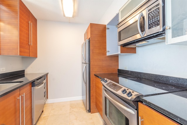 kitchen with light tile patterned floors, stainless steel appliances, and sink