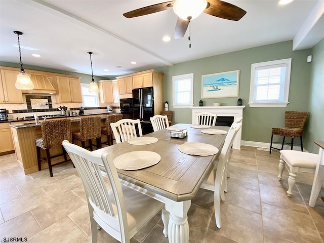 tiled dining space with a healthy amount of sunlight and ceiling fan