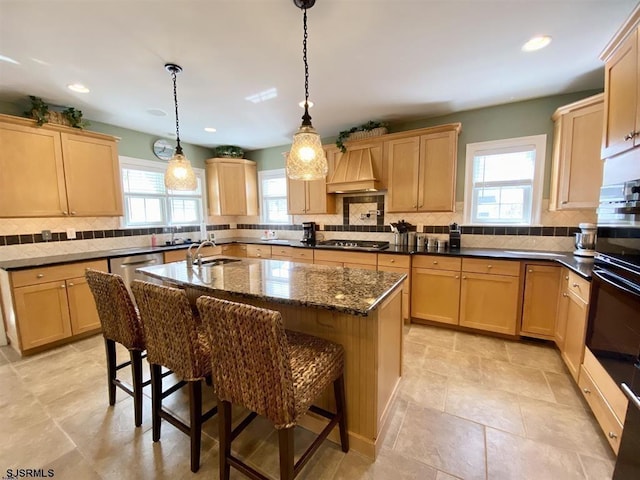 kitchen featuring a breakfast bar area, hanging light fixtures, a kitchen island, custom exhaust hood, and light brown cabinets