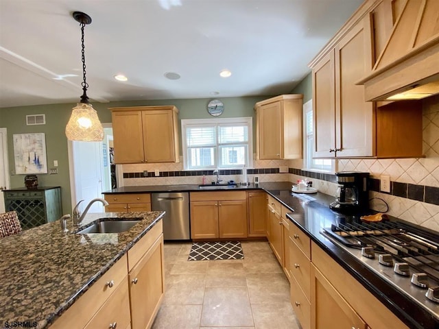 kitchen with stainless steel appliances, sink, pendant lighting, and dark stone counters