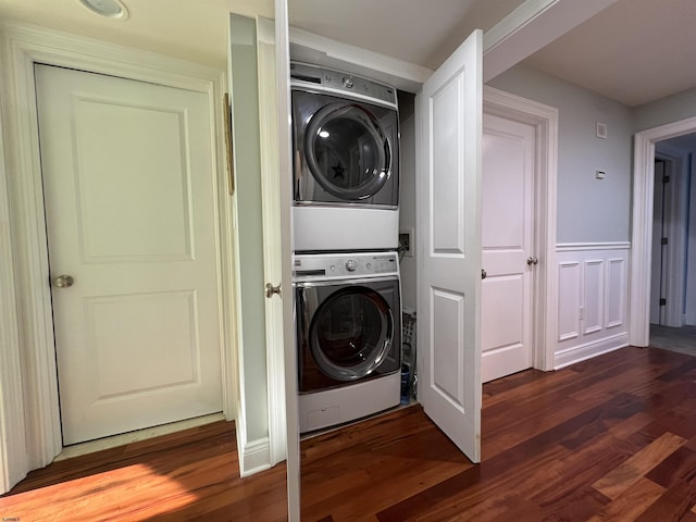 clothes washing area with stacked washer / dryer and dark wood-type flooring