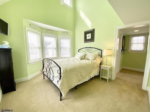 carpeted bedroom with a towering ceiling