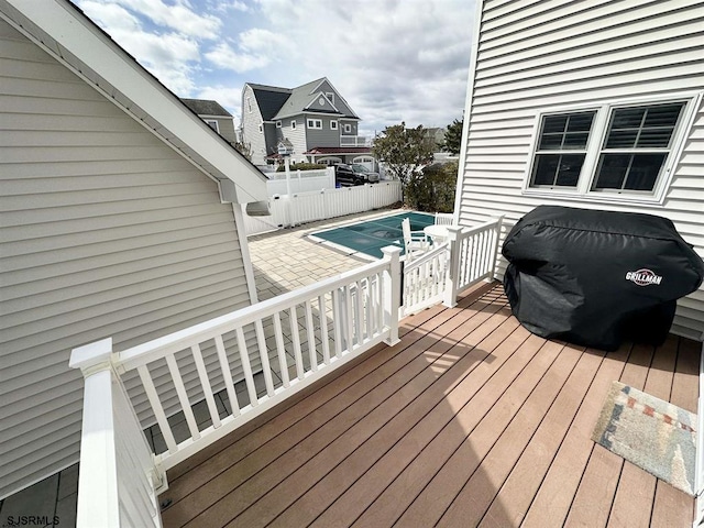 wooden terrace with a swimming pool and a patio area