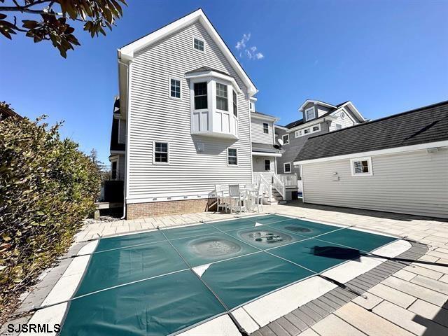 exterior space featuring a patio and a covered pool