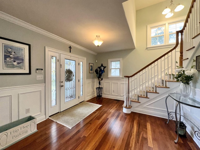 entryway featuring dark hardwood / wood-style flooring, a notable chandelier, and crown molding