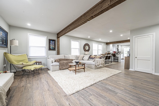 living room with beam ceiling and wood-type flooring