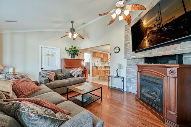 living room with ceiling fan, ornamental molding, and wood-type flooring