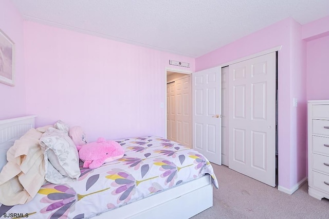 carpeted bedroom with a closet and a textured ceiling