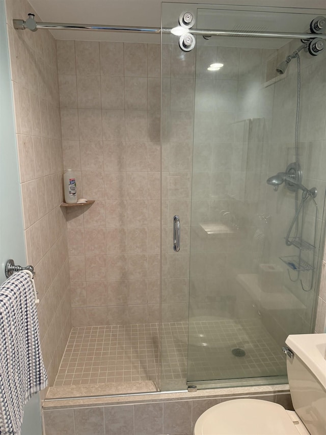 bathroom with an enclosed shower and toilet