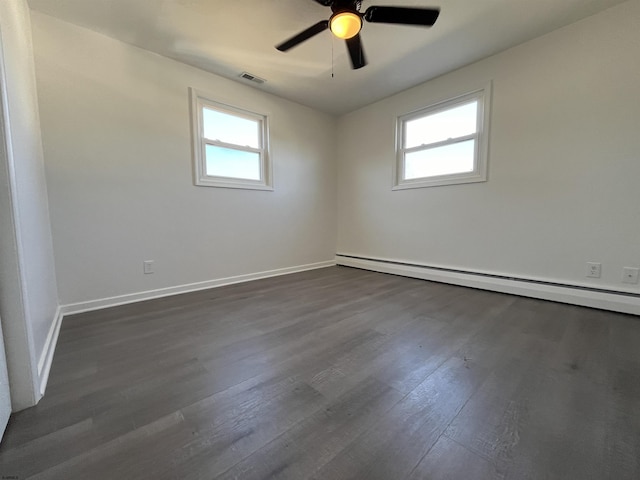 empty room with baseboard heating, ceiling fan, plenty of natural light, and dark hardwood / wood-style floors