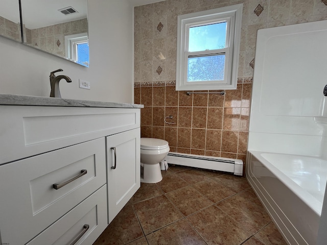 full bathroom with tile walls, a baseboard heating unit, vanity, and plenty of natural light