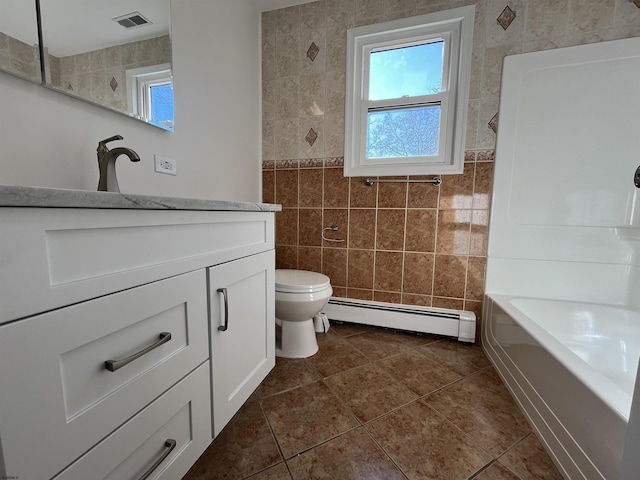 full bathroom with tile walls, vanity, a healthy amount of sunlight, and baseboard heating