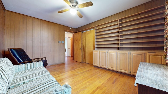 interior space featuring wood walls, ceiling fan, and light hardwood / wood-style flooring