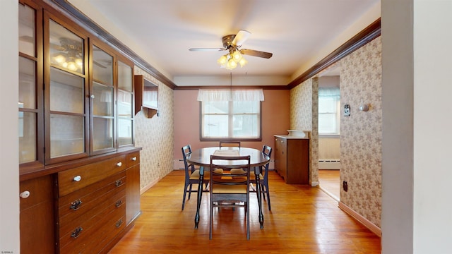 dining space with ceiling fan, a baseboard radiator, and light hardwood / wood-style floors