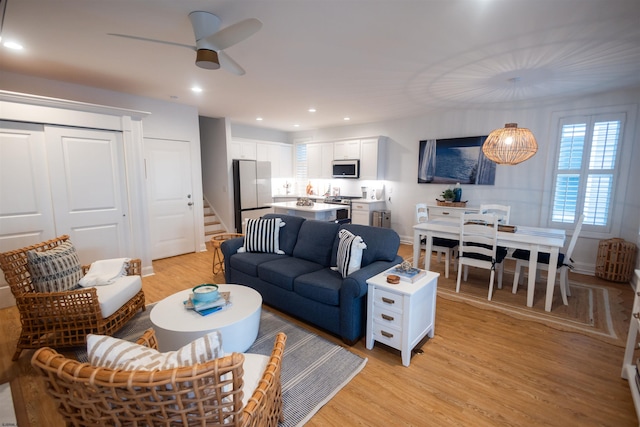 living room featuring ceiling fan and light wood-type flooring