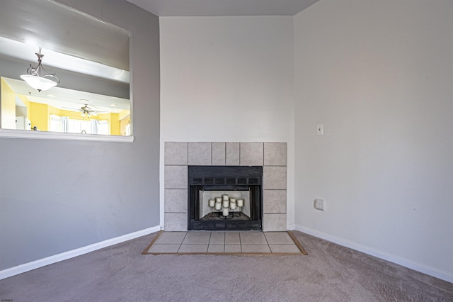 unfurnished living room featuring a tiled fireplace, light colored carpet, ceiling fan, and beamed ceiling