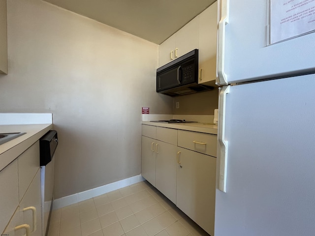 kitchen featuring light tile patterned floors, white cabinets, and white appliances