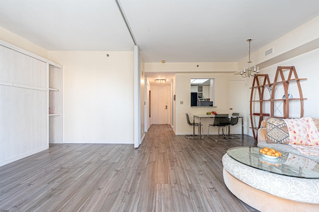 living room with light hardwood / wood-style flooring and a chandelier