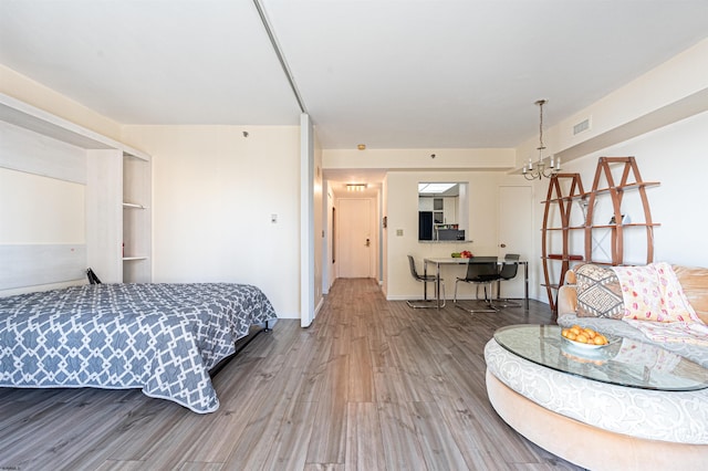 bedroom featuring a notable chandelier and wood-type flooring