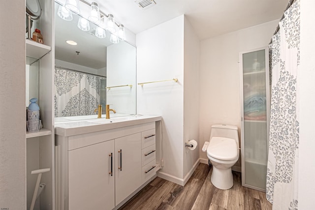 bathroom with hardwood / wood-style flooring, vanity, and toilet