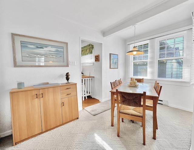 carpeted dining room with beam ceiling and a baseboard radiator