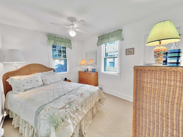 bedroom with multiple windows, light colored carpet, and ceiling fan