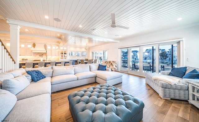 living room with ceiling fan, beam ceiling, wood-type flooring, wooden ceiling, and ornate columns