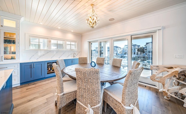 dining room with crown molding, wooden ceiling, and light hardwood / wood-style flooring