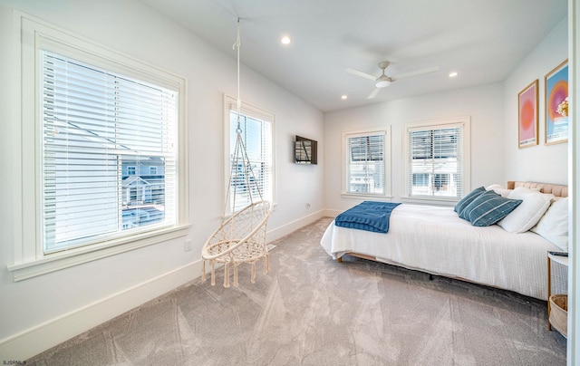 carpeted bedroom featuring multiple windows and ceiling fan