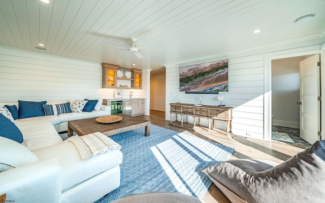 living room with ceiling fan, bar, light hardwood / wood-style flooring, and wooden ceiling