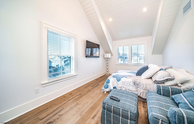 bedroom featuring vaulted ceiling with beams, hardwood / wood-style floors, and wooden ceiling