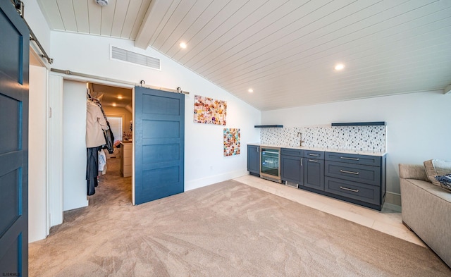 interior space featuring vaulted ceiling with beams, wine cooler, bar area, light colored carpet, and a barn door