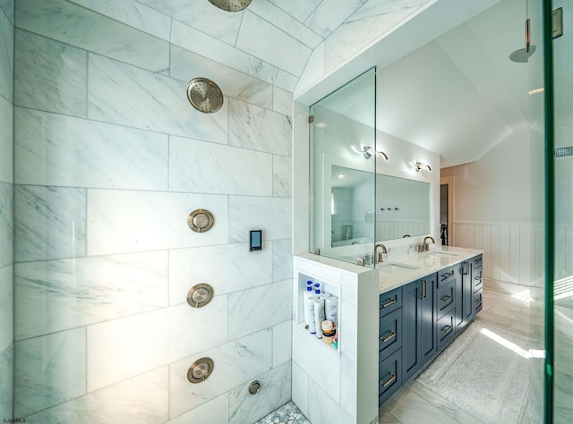 bathroom with lofted ceiling, vanity, and tiled shower