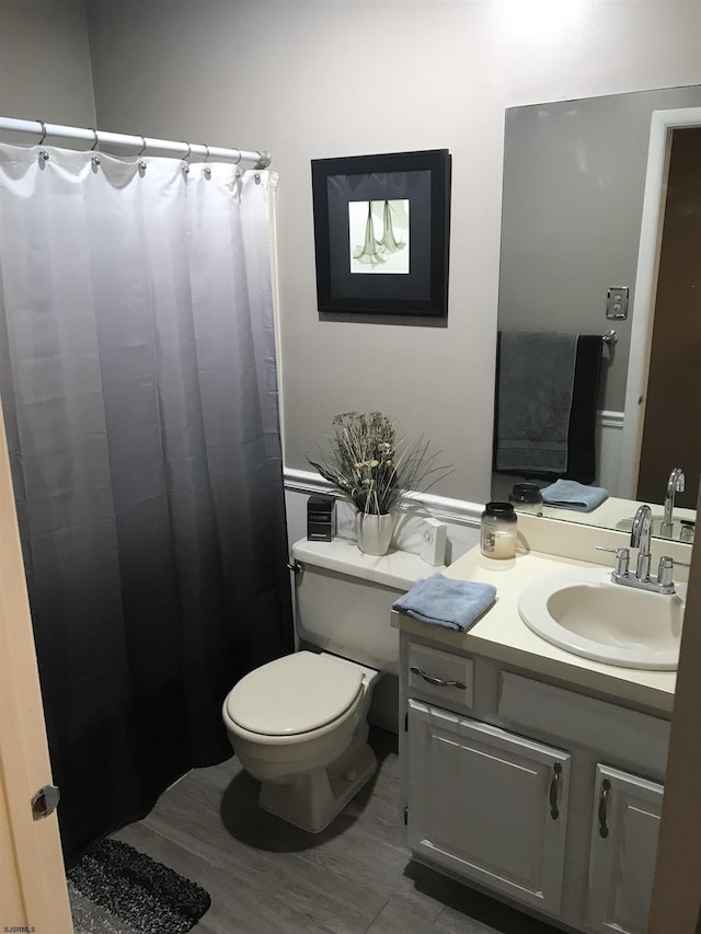 bathroom with vanity, wood-type flooring, and toilet