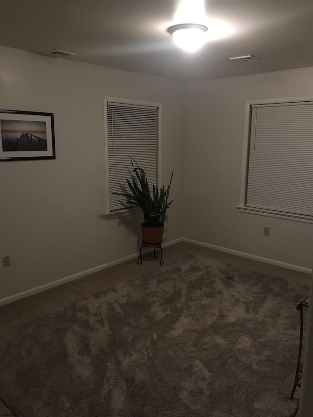 spare room featuring dark colored carpet