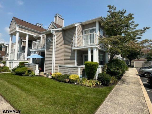 view of property exterior featuring a yard and a balcony