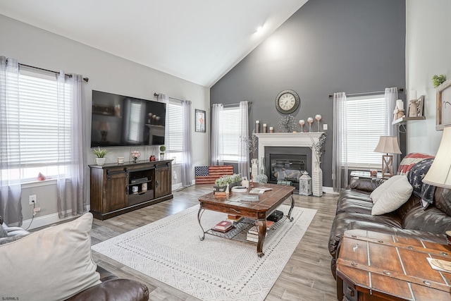 living room with high vaulted ceiling and light wood-type flooring