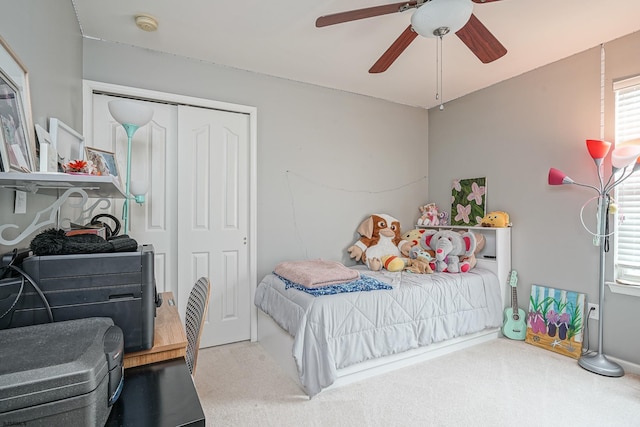 carpeted bedroom featuring ceiling fan and a closet