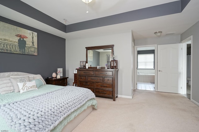 bedroom featuring light colored carpet and ensuite bathroom