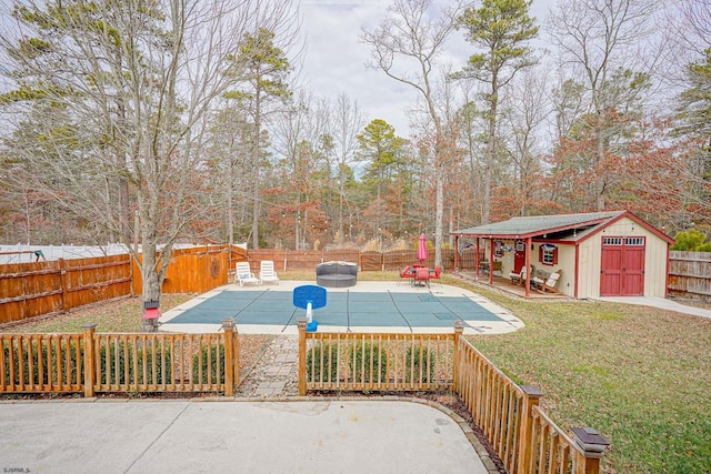 view of pool featuring a yard, a patio area, and a storage unit