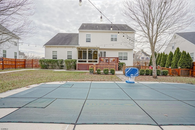 rear view of property with a pool side deck and a yard