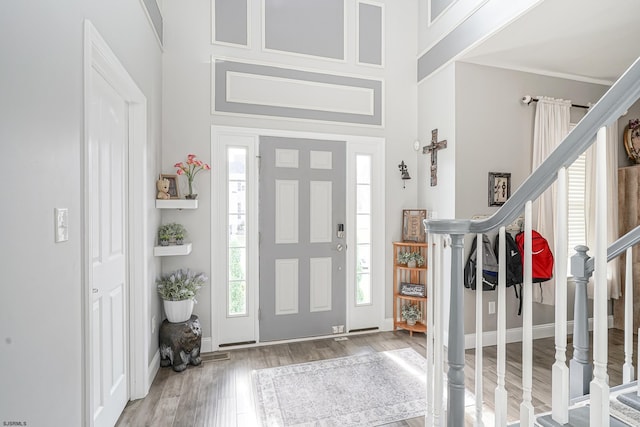 foyer entrance with hardwood / wood-style flooring and a towering ceiling