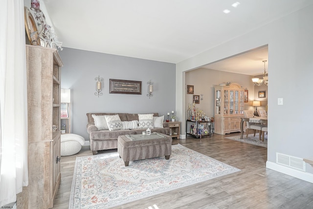 living room with wood-type flooring and a chandelier